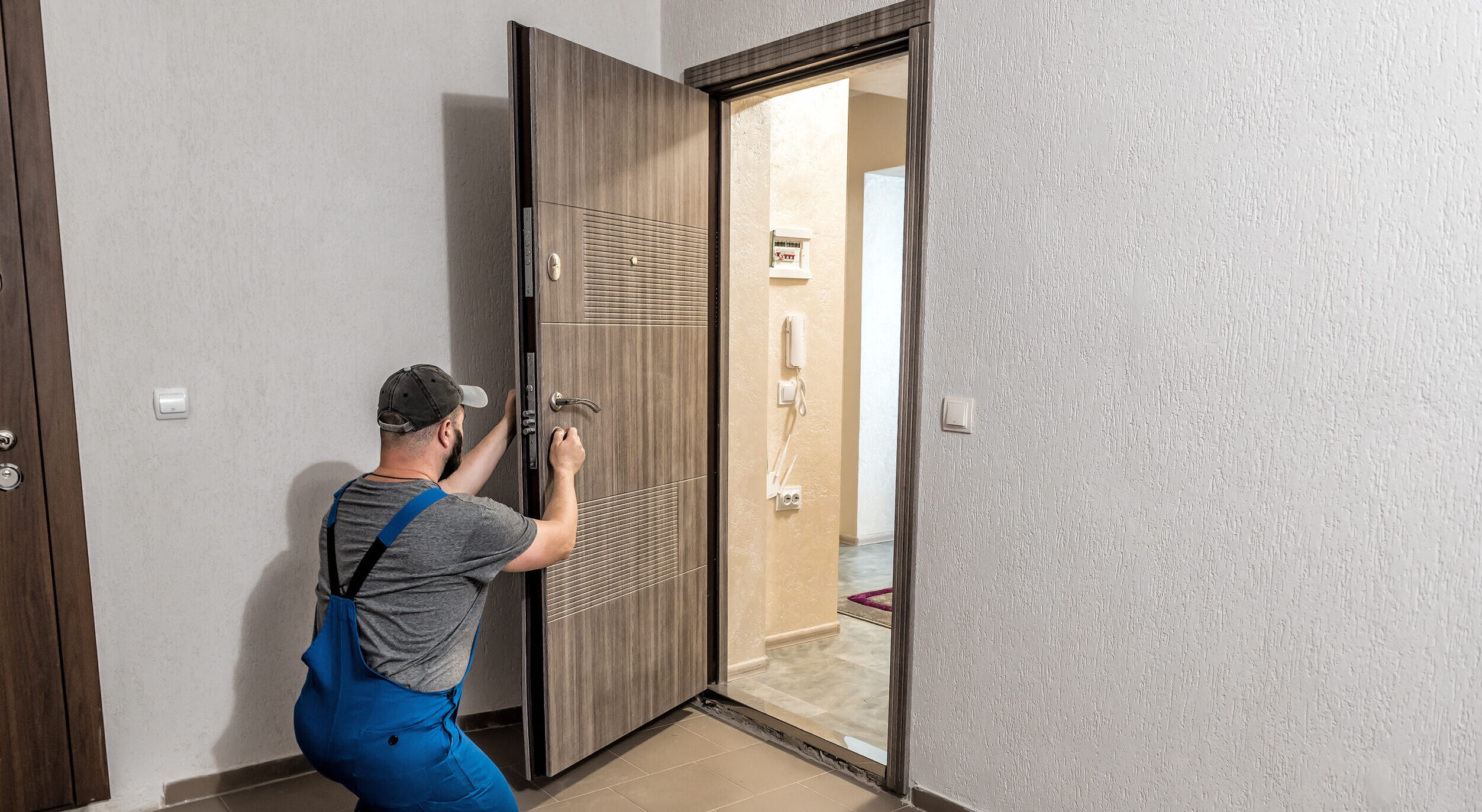 Professional locksmith repairing installing home entrance door lock